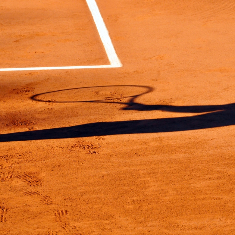 Tennis player shadow on a clay tennis court