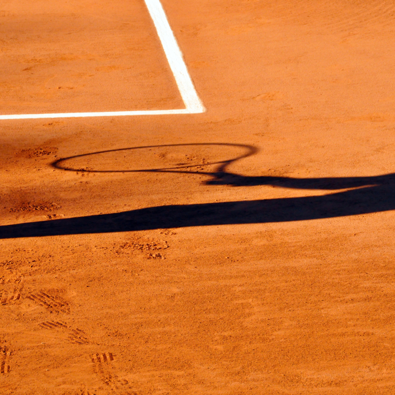 Tennis player shadow on a clay tennis court